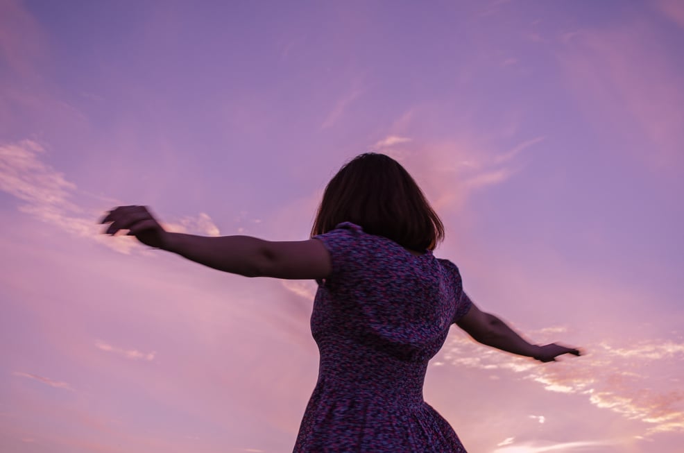 Woman in Purple Dress Raising Her Hands